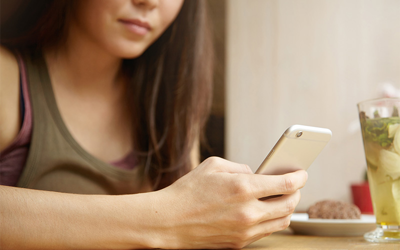 Woman checking her phone constantly due to FOMO